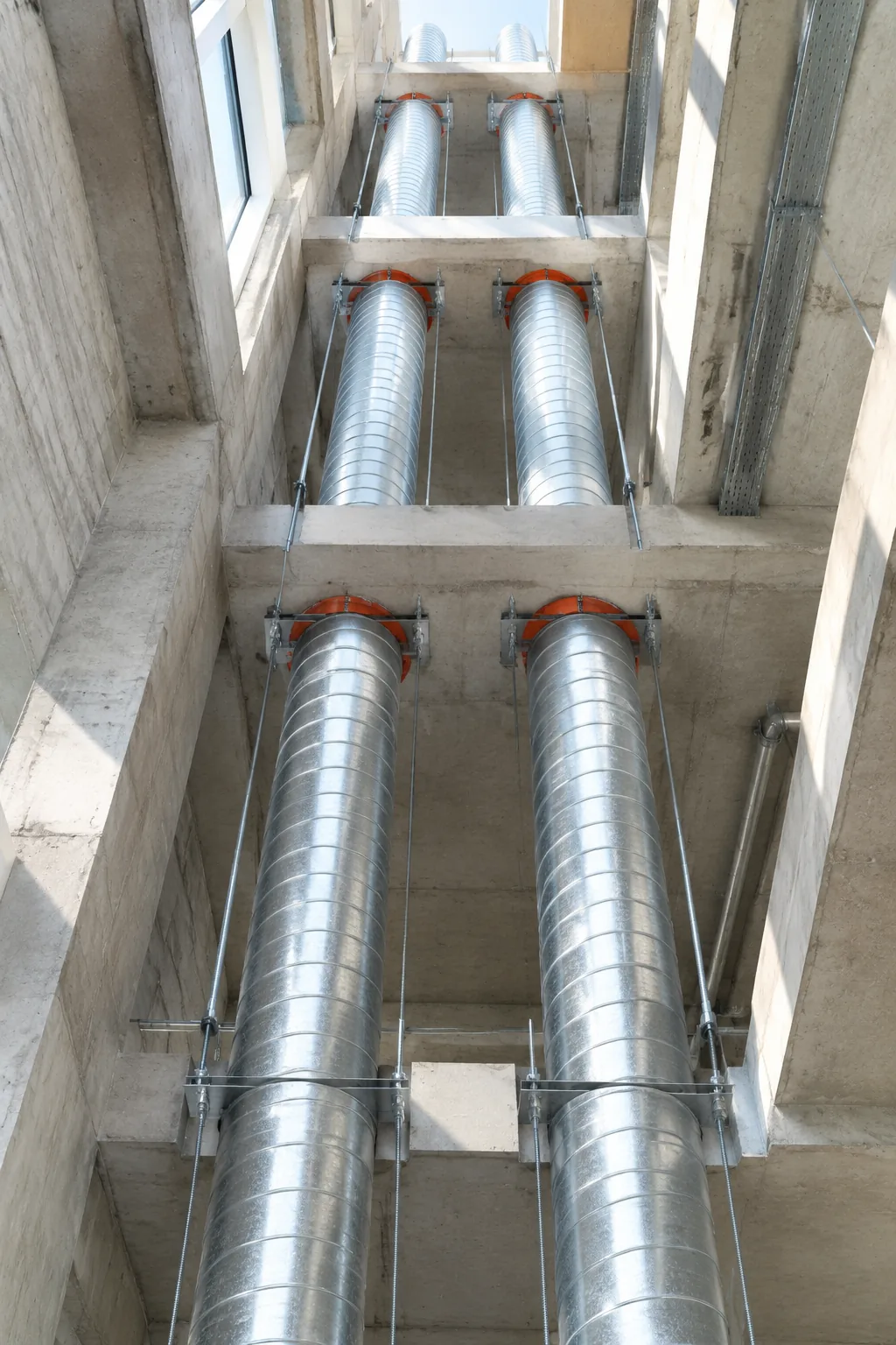 Rectangular duct run supported from a concrete soffit